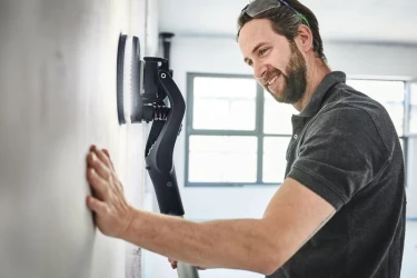Handwerker schleift eine Wand ab