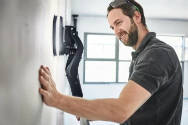 Handwerker schleift eine Wand ab